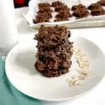 No Bake Cookies on white plate next to oats, milk, and on sheet pan