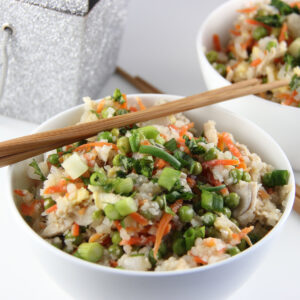 Cauliflower Fried Rice with chopsticks and sparkly take out container