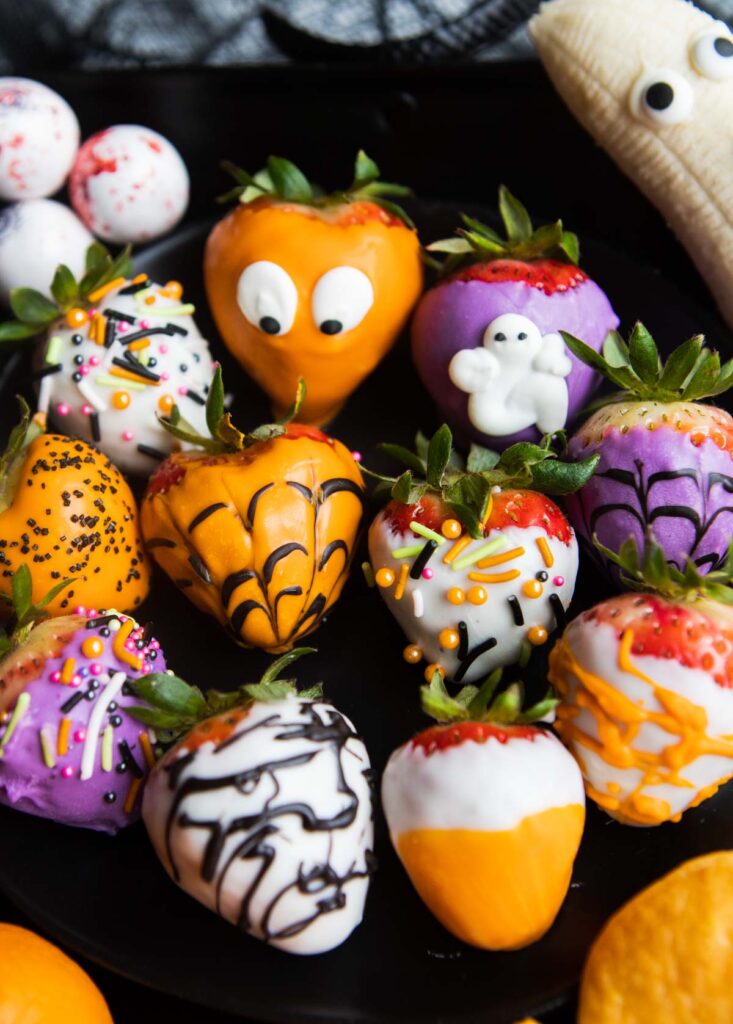 Chocolate covered strawberries with Halloween decorations.