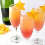 Hawaiian Sunrise Healthy Mimosas decorated with star fruit and low sugar champagne.