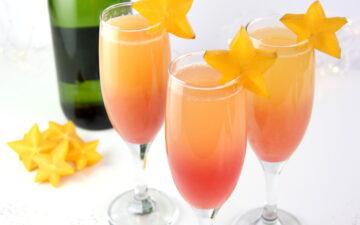 Hawaiian Sunrise Healthy Mimosas decorated with star fruit and low sugar champagne.