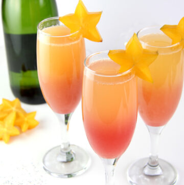 Hawaiian Sunrise Healthy Mimosas decorated with star fruit and low sugar champagne.