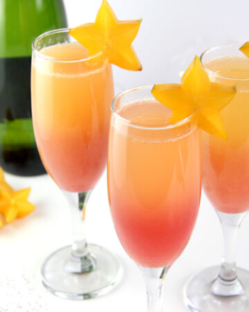 Hawaiian Sunrise Healthy Mimosas decorated with star fruit and low sugar champagne.