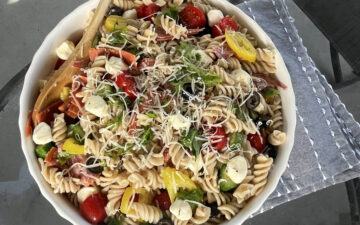 Gluten Free Pasta Salad served outside with wood spoon on blue napkin