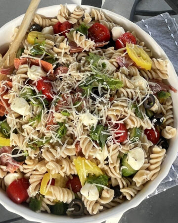 Gluten Free Pasta Salad served outside with wood spoon on blue napkin