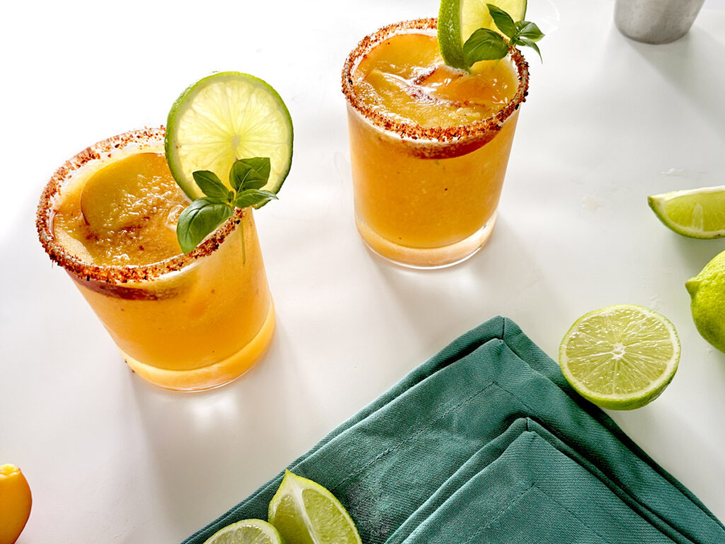 Two Hot Honey Peach Margaritas and blue napkin