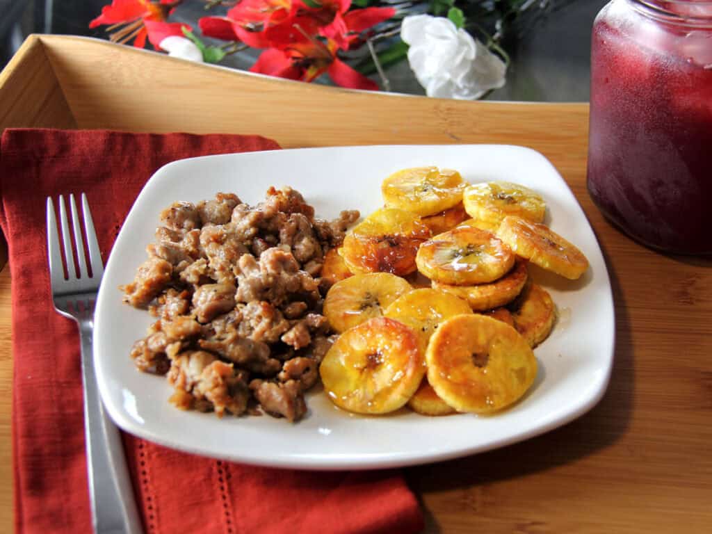 Ground sausage and fried plantains served with unsweet fruity black tea in mason jar.