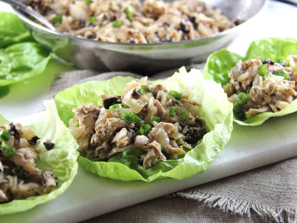 Chicken Lettuce Wraps with filling in bowl behind them