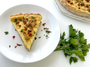 Gluten Free Quiche Lorraine on plate with parsley and quiche plate next to it