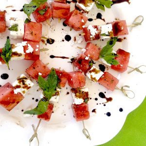 Watermelon Basil Feta Skewers on White Platter with Bright Green Background