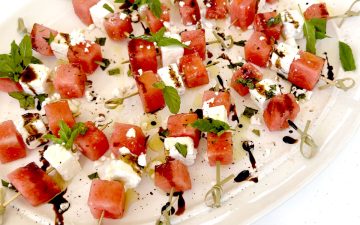 Watermelon Basil Feta Skewers on White Platter with Bright Blue Background