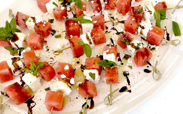 Watermelon Basil Feta Skewers on White Platter with Bright Blue Background